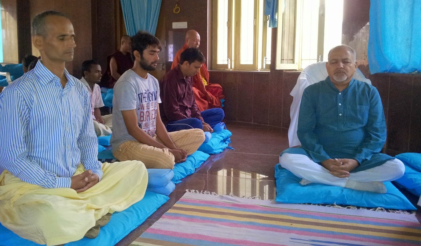 विपश्यना में साधक का शरीर घनता से तरंगों में बदलता हुआ – ध्यान में बैठा व्यक्ति जिसके शरीर के चारों ओर कंपन और ऊर्जा तरंगों का प्रतीकात्मक बहाव दिखाया गया हो, शांत और सरल पृष्ठभूमि में।