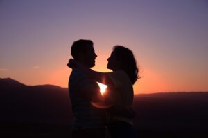 Two lovers hugging each other at sunset. 